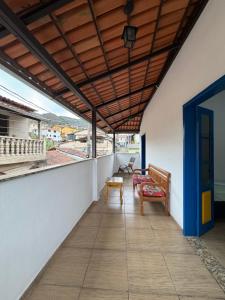 Un balcón con dos bancos y toldo en un edificio. en Pousada Jardineira, en Ouro Preto