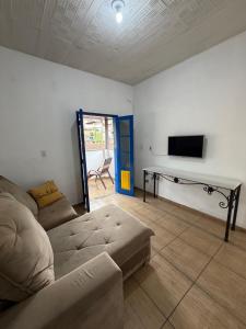 Una sala de estar con un sofá y un televisor de pantalla plana. en Pousada Jardineira, en Ouro Preto