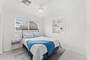 una camera da letto bianca con un letto e una finestra di 921 S Orlando Ave a Cocoa Beach Altre 55 foto