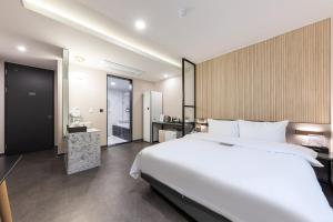 a bedroom with a large white bed and a bathroom at Hotel 24st Prestige in Seosan +66 photos
