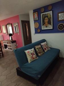 a living room with a blue couch with pillows at Amplio, equipado con vistas a jardín en el corazón CDMX in Mexico City