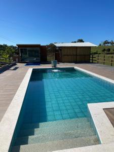 a swimming pool in a backyard with a house at Pousada Peninsula Santa Rita in Guarapari