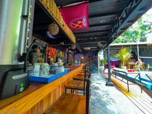 a bar in a food truck with wooden tables and benches at Surf Town Hostel in San Juan del Sur
