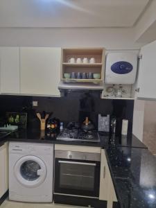 a kitchen with a stove and a washing machine at Sunny studio with a beautiful terrace in Pont Blondin