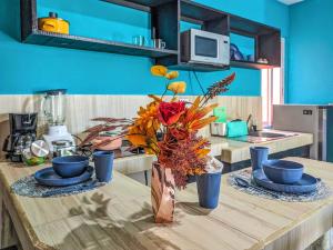 una mesa de cocina con un jarrón de flores. en Romantic Escape I 500m Award-Winning Beach I Memory Foam King Bed I AC Kitchen WiFi 5B, en Playa del Carmen