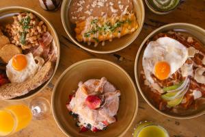 a table topped with four bowls of different types of food at Dream Haus Country Club in Guadalajara