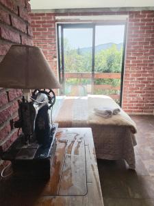 une chambre avec un lit et une lampe sur une table dans l'établissement Vinoteca Vintage, à Piriápolis