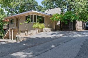 una pequeña casa en una calle al lado de una carretera en Relaxing River Retreat Near Moms Beach with Patio, en Hacienda
