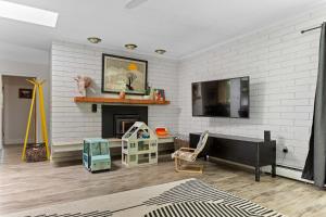 Una sala de estar con chimenea y televisión. en Relaxing River Retreat Near Moms Beach with Patio, en Hacienda