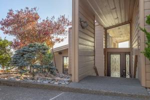 a house with a wooden door and a tree at Expansive Ocean-View Retreat with Home Theatre & Spa in Bodega Bay