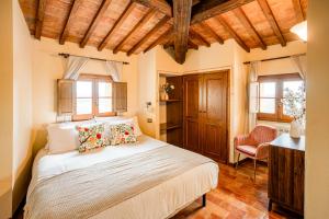 ein Schlafzimmer mit einem Bett und einem Stuhl in der Unterkunft La Lunaria di Lajatico in Laiatico + 100 Fotos