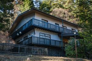 a large house with a balcony on the side of it at Fujisan Lodge En in Fujikawaguchiko