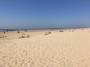 a group of people laying on a beach at Group home with sauna near the beach and sea in Julianadorp +1 photo