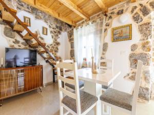 a living room with a table and chairs and a tv at Rustical Resort Kokori i with Shared Outdoor Swimming Pool - One Bedroom Apartment with Terrace in Višnjica