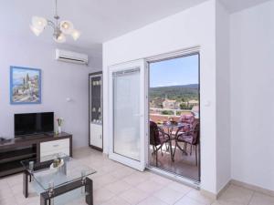 Una sala de estar con balcón con mesa y televisión. en One Bedroom Apartment with Balcony and Sea View 2, en Vrboska