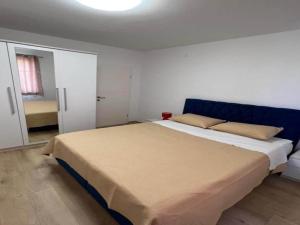 a bedroom with a large bed with a blue headboard at Four-Bedroom Apartment With Sea View in Sreser