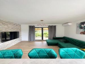 sala de estar con sofá verde y chimenea en Four-Bedroom Apartment With Sea View, en Sreser