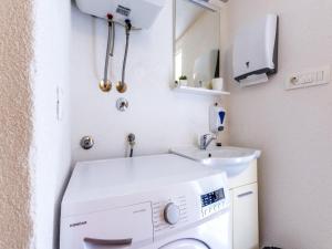 a small bathroom with a washing machine and a sink at House with Two Bedrooms Dinko HH in Višnjica