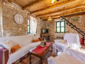 a living room with couches and a clock on the wall at House with Two Bedrooms Dinko HH in Višnjica