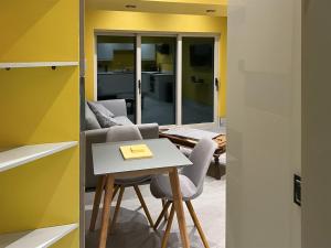 a room with a table and two chairs and a room with yellow walls at Peartree Cottage in Sheffield