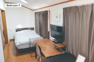 a bedroom with a desk with a television and a bed at f life house - Vacation STAY 18973 in Koriyama