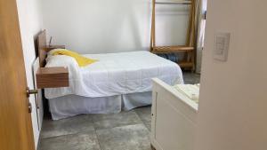 a small bedroom with a bed and a mirror at Departamento Abril Sierras in Tandil