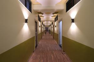 an empty corridor of a building with lights on the walls at Hotel O Shri Sai Niwara Lodge in Dhule