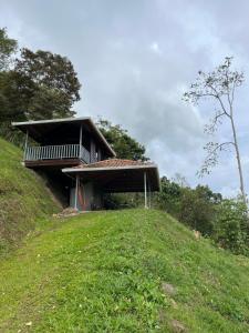 a house on top of a grassy hill at Cabaña Doña Flor in Turrialba