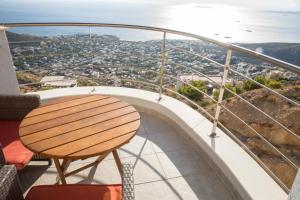a table on a balcony with a view of a city at Viva B&B in Anavyssos