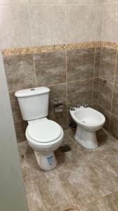 a bathroom with a toilet and a sink at Departamento Abril Sierras in Tandil
