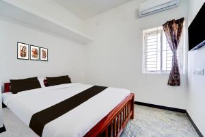 コインバトールにあるSuper Hotel O Neelambur Near PSG ITechのベッドと窓のある白い寝室