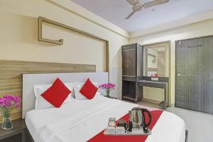 a hotel room with a bed with red pillows at Hotel O Saidan Lodging & Boarding in Mumbai +20 photos