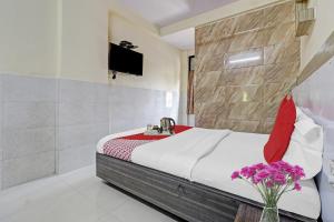 a bedroom with a bed with a sink and flowers at Hotel O Saidan Lodging & Boarding in Mumbai