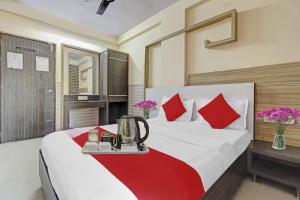 a bedroom with a large bed with red pillows at Hotel O Saidan Lodging & Boarding in Mumbai