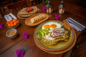 a wooden table with a plate of breakfast food at Hacienda Gobernadores Boutique Stay in a Historic 19th-Century Hacienda in Mexico City