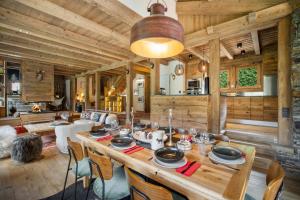 ムジェーヴにあるLuxury Megeve Chalet 4BR 10p Fireplace Mountain Views and Gardenのテーブルと椅子付きの広いダイニングルーム