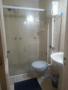 a bathroom with a shower and a toilet and a sink at Mamma's Hostel e Pousada in Caxias do Sul