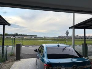 a blue car is parked at a gas station at Homestay Tok in Tapah Road