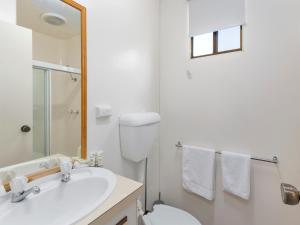a white bathroom with a toilet and a sink at Shoalhaven Heads Village in Shoalhaven Heads +27 photos