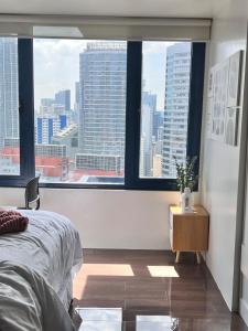 Schlafzimmer mit einem großen Fenster mit Stadtblick in der Unterkunft Pleasant Air Residences City View in Sampong