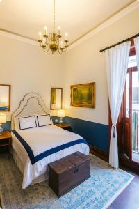 a bedroom with a bed and a chandelier at Hacienda Gobernadores Boutique Stay in a Historic 19th-Century Hacienda in Mexico City