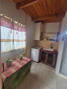 Una pequeña cocina con una mesa y un fregadero. en Rincón del Shoam, en Gobernador Gregores