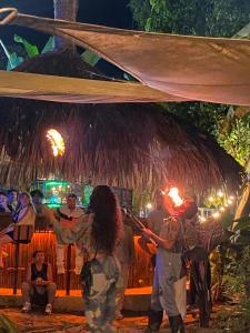a group of people standing under a thatch umbrella at Minkanta Central Hostel in Minca