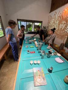 a group of people standing around a blue table at Minkanta Central Hostel in Minca