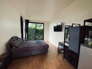 a bedroom with a bed and a large window at คุณหนูแดง รีสอร์ท 