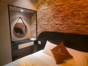 a bedroom with a brick wall and a bed with a mirror at NP Luxury Motel in Ấp Hưng Lộc