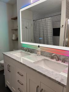 a bathroom with two sinks and a large mirror at Hidden Gem Hot tub pool table - EV charger Sleep number Bed in Perry Manor +93 photos
