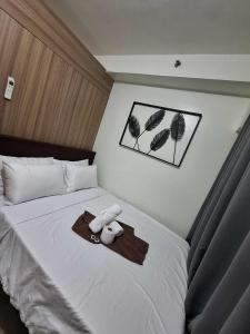 a bed with a teddy bear and a tray on it at SHORE Staycation in MOA by MLG in Manila