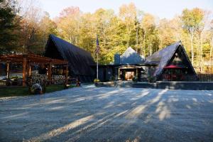 a large black building with a pavilion in a forest at Rent An Inn! Takeover the Birch Ridge with your group, Mountain Lodge- 11 Rooms, Bar, Fireplace, 28ppl home in Killington