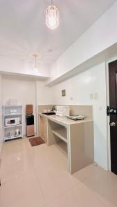 a white kitchen with a counter and a stove at Mactan Airport HOSTEL at Aashvi Cozy Cabin in Pusok